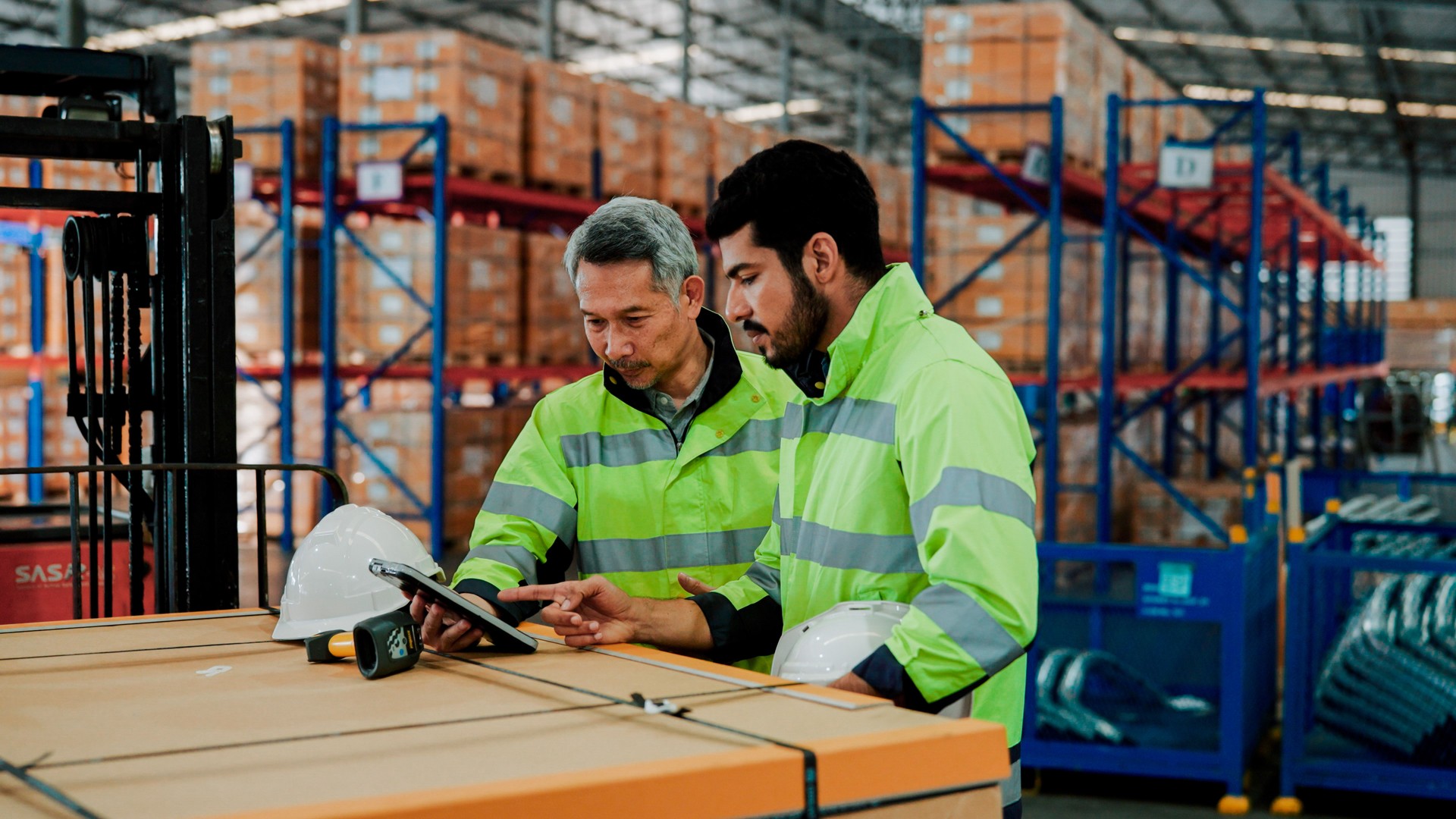 Adult Asian Manager Explaining Work Process Improvement to Warehouse Worker.